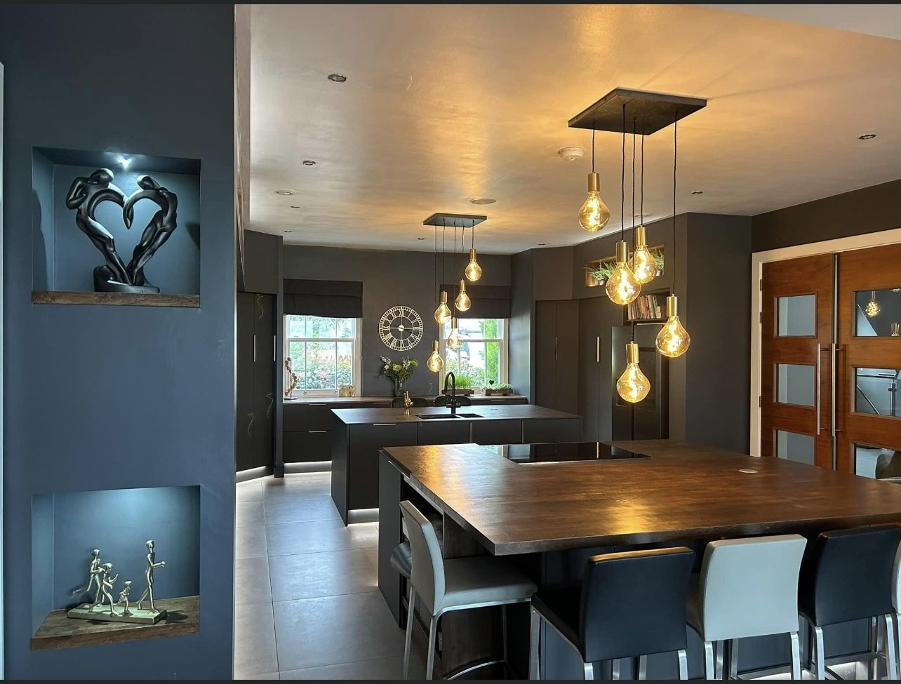 Bespoke dark kitchen with dining table and brass pendant lighting
